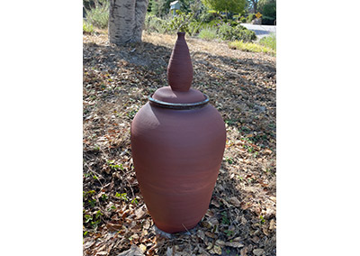Large lidded pot decorating a garden